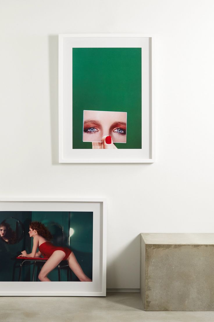 two framed photographs hang on the wall next to each other, one with a woman's face