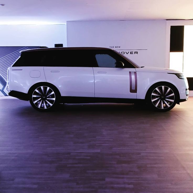 a white range rover parked in a showroom