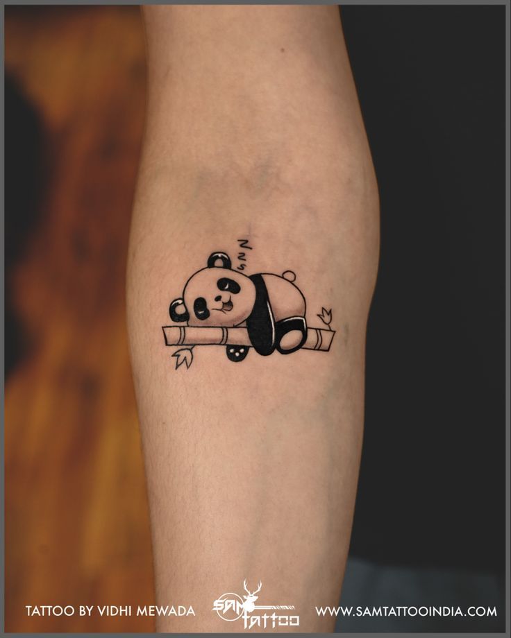 a small panda bear tattoo on the leg