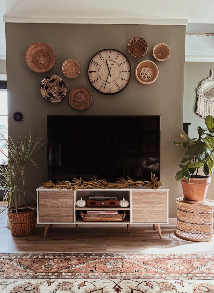 a large flat screen tv sitting on top of a wooden entertainment center in a living room