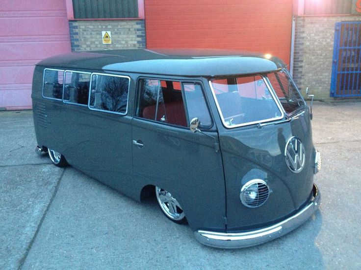 an old vw bus parked in front of a garage