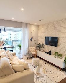 a living room filled with furniture and a flat screen tv mounted on a wall above a fireplace