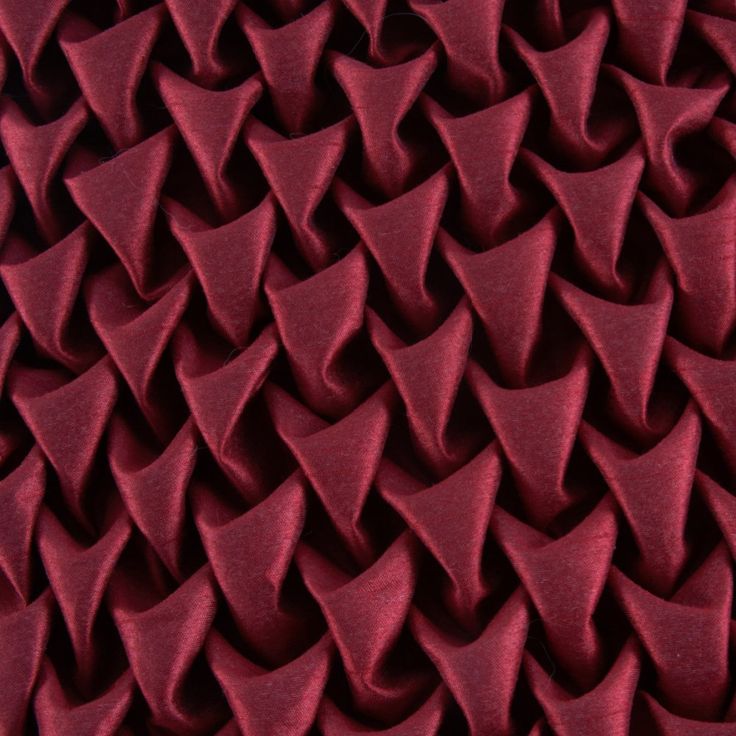 an up close shot of red fabric with many small triangles on the top and bottom