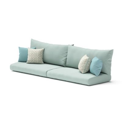 an outdoor sofa with pillows on the back and two cushions on the front, sitting against a white background