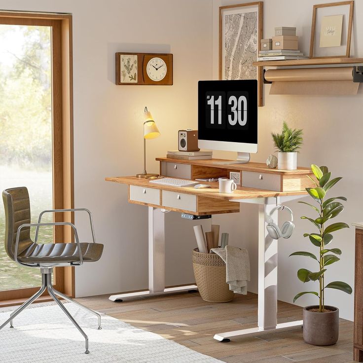 a computer desk with a clock on the wall next to a chair and potted plant