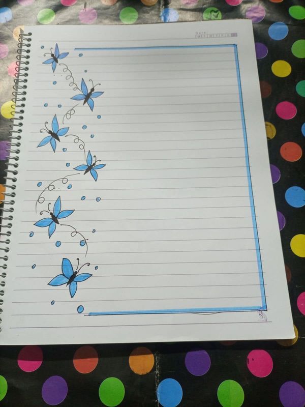 a notebook with blue butterflies on it sitting on a polka dot tablecloth covered surface