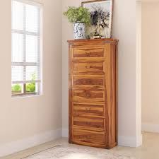 a tall wooden dresser sitting next to a window