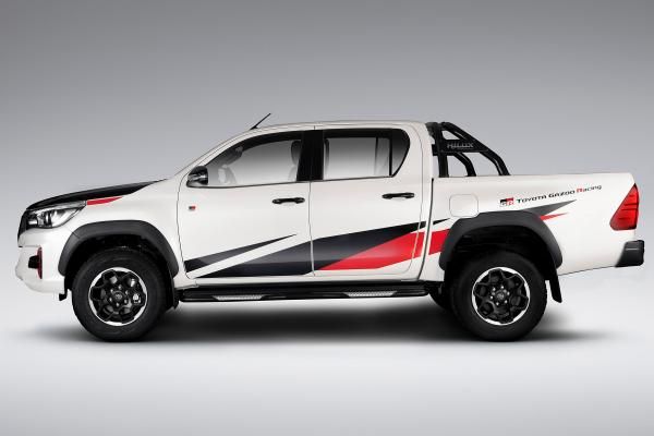 a white truck with red and black stripes on it's side, in front of a gray background