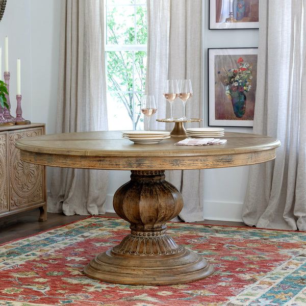 a dining room table with candles on it in front of a window and pictures hanging on the wall