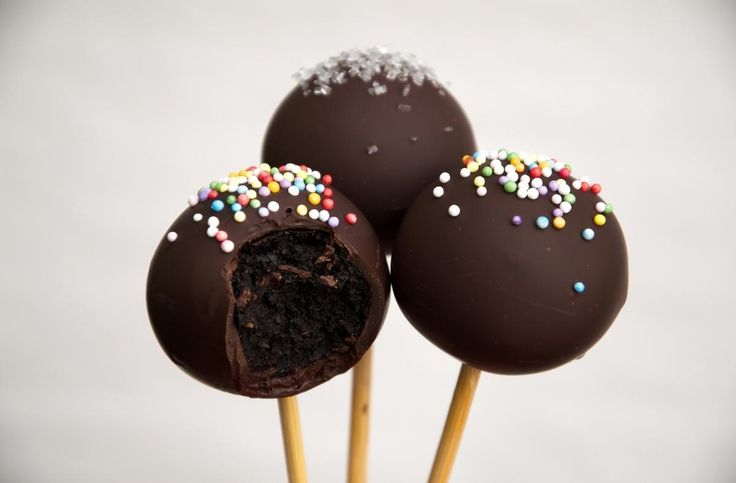 three chocolate cake pops with sprinkles on top