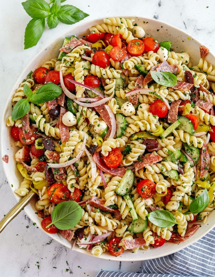 a bowl filled with pasta salad on top of a table