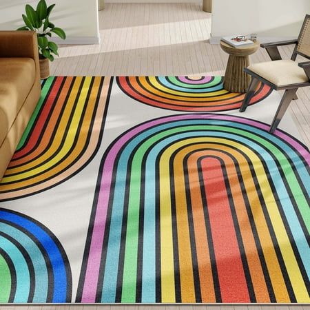 a colorful area rug in the middle of a living room with a couch and chair