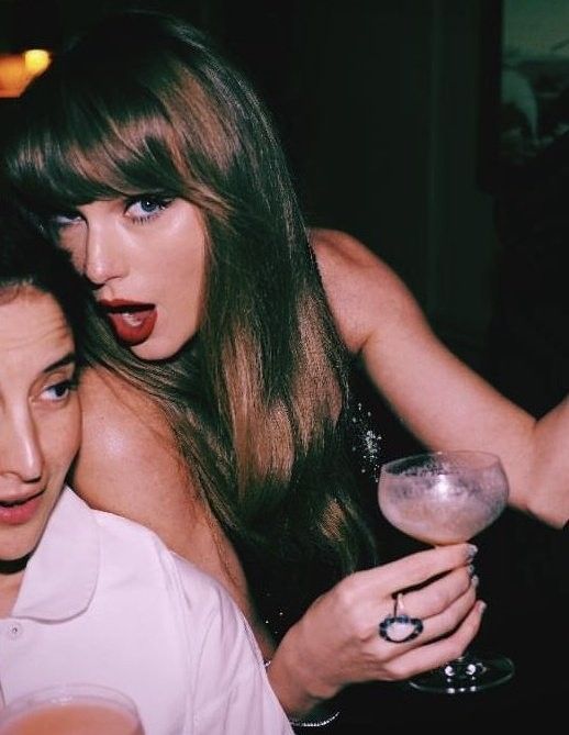 two beautiful women sitting next to each other at a bar with drinks in their hands