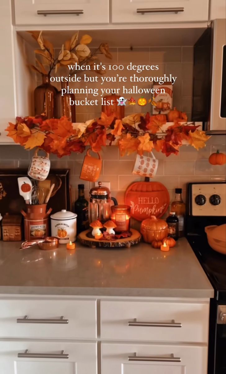 the kitchen counter is decorated with fall leaves and candles for decor, including pumpkins