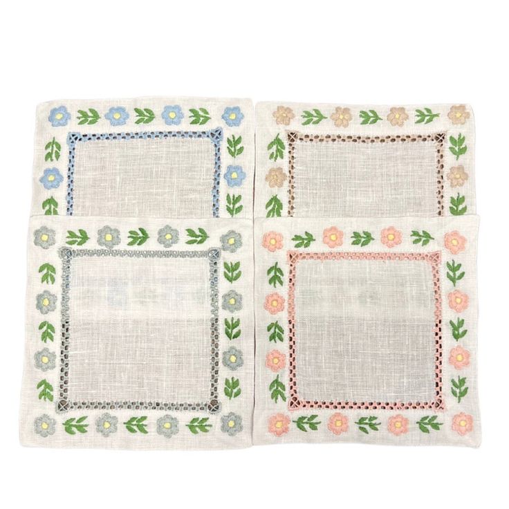 three placemats with flowers and leaves on the edges, one has a white linen backing