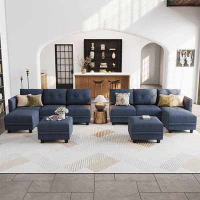 a living room with blue couches and white rugs on the floor in front of a fireplace