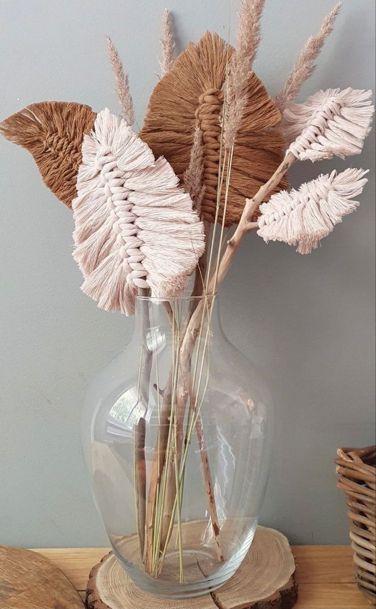 dried flowers in a glass vase on a table