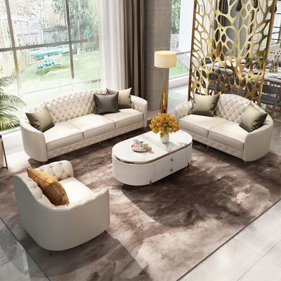 a living room filled with white couches and chairs on top of a brown rug