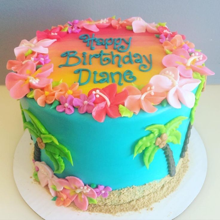 a birthday cake decorated with flowers and palm trees