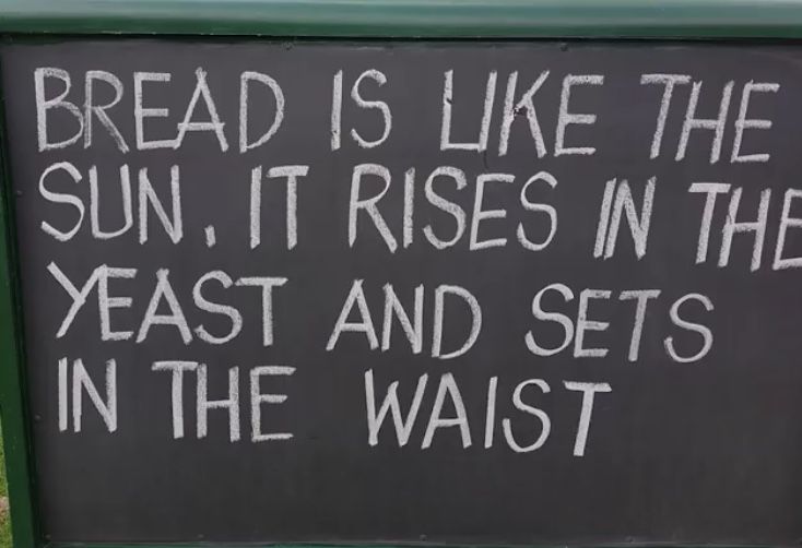 a chalkboard sign with writing on it that reads bread is like the sun, it rises in the yeast and sets in the waist