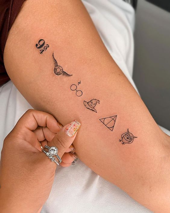 a woman's arm with tattoos on it, including harry potter and her symbols