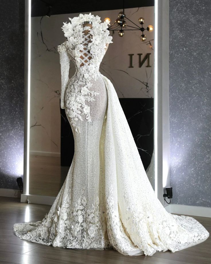 a white wedding dress on display in a room