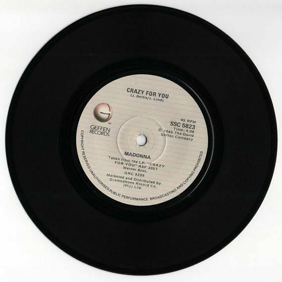 the label for an album on a black record disk with white writing and a small round hole in the center