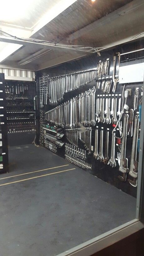 a room filled with lots of different types of wrenches and pliers hanging from the ceiling