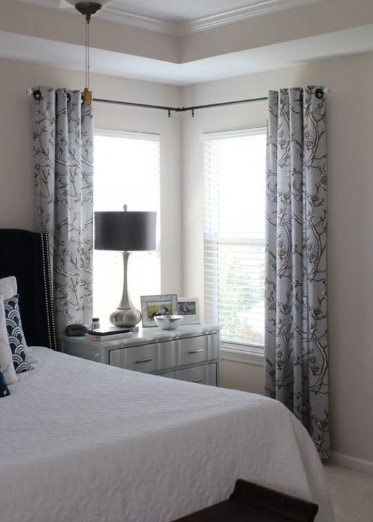 a bedroom with white bedding and curtains