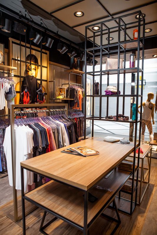 the inside of a clothing store with clothes on racks