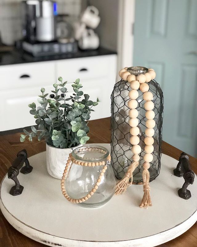 a wooden bead necklace sitting on top of a table next to a potted plant