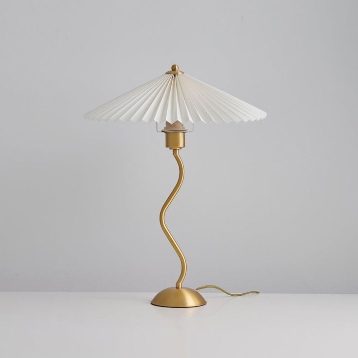 a lamp that is on top of a white table with a light bulb in the middle