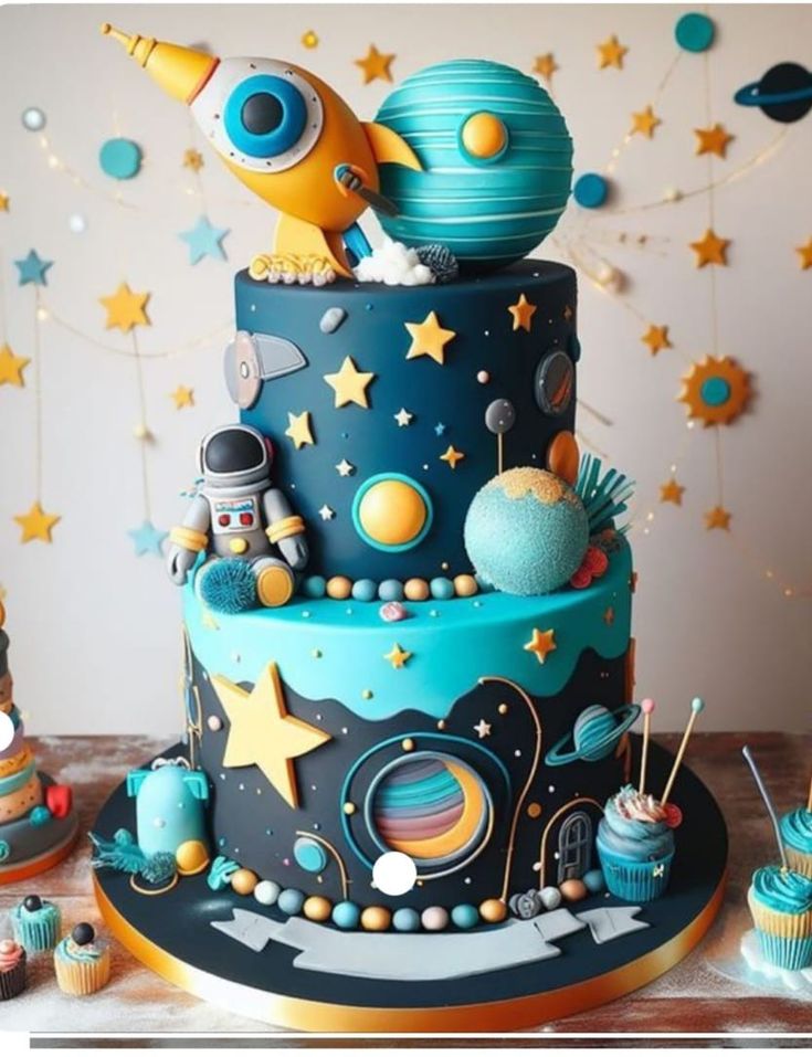 a space themed birthday cake with cupcakes and stars