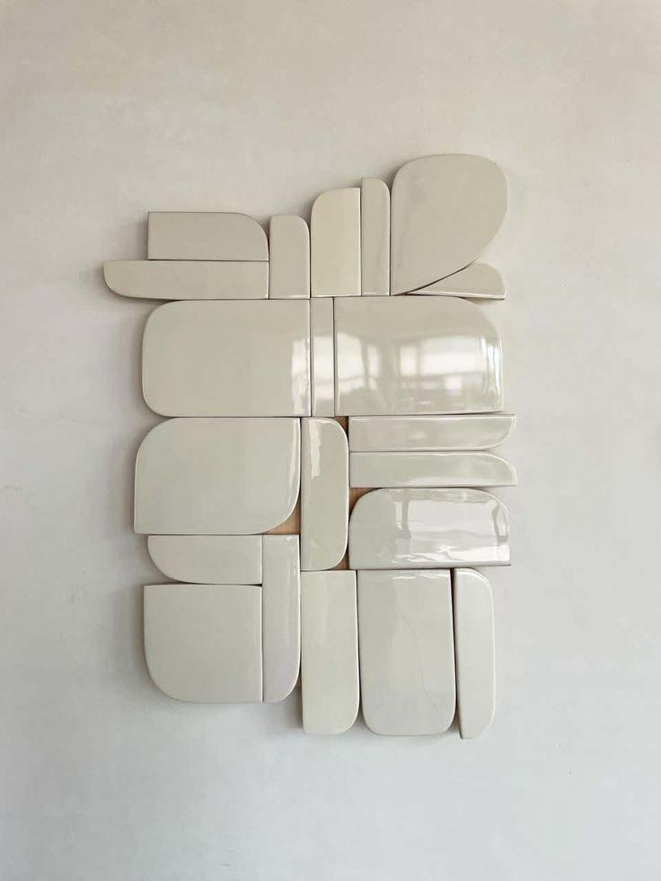 several pieces of white ceramic are arranged on the wall