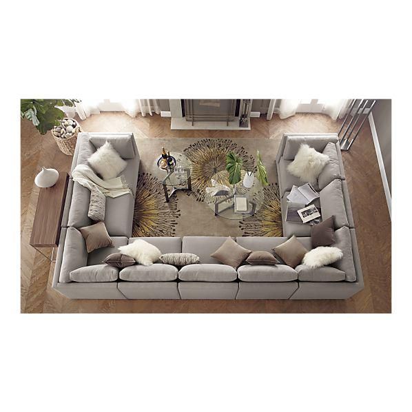 an overhead view of a living room with grey couches and white pillows on the floor