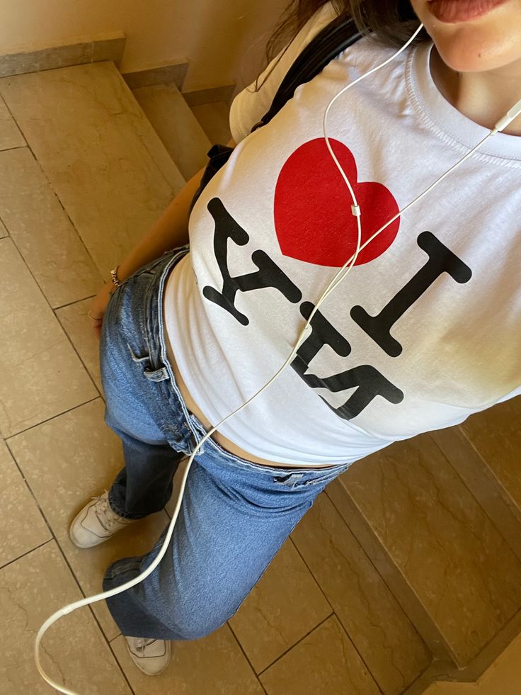 a woman with headphones in her ears is standing on the floor and listening to music