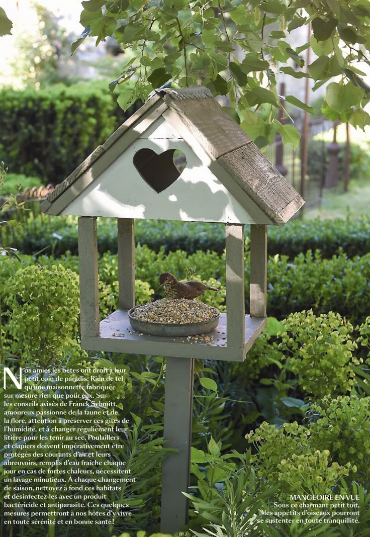 a bird feeder in the shape of a house with a heart on it's roof