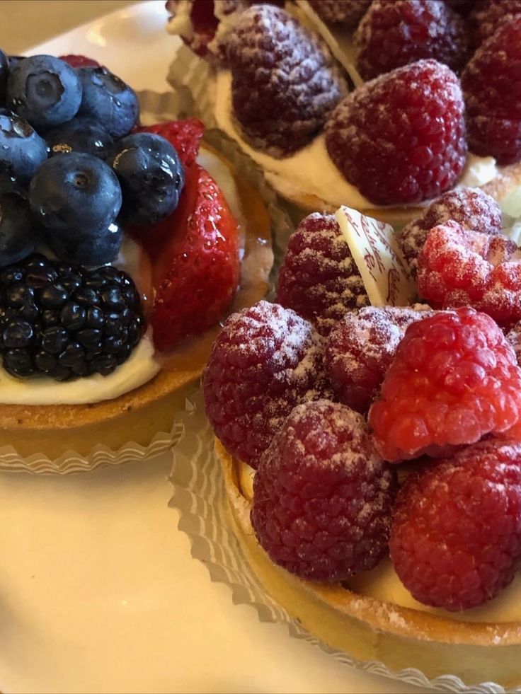 three pastries with berries and blueberries on them