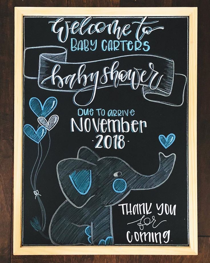 a chalkboard sign for a baby shower with an elephant and hearts on the back