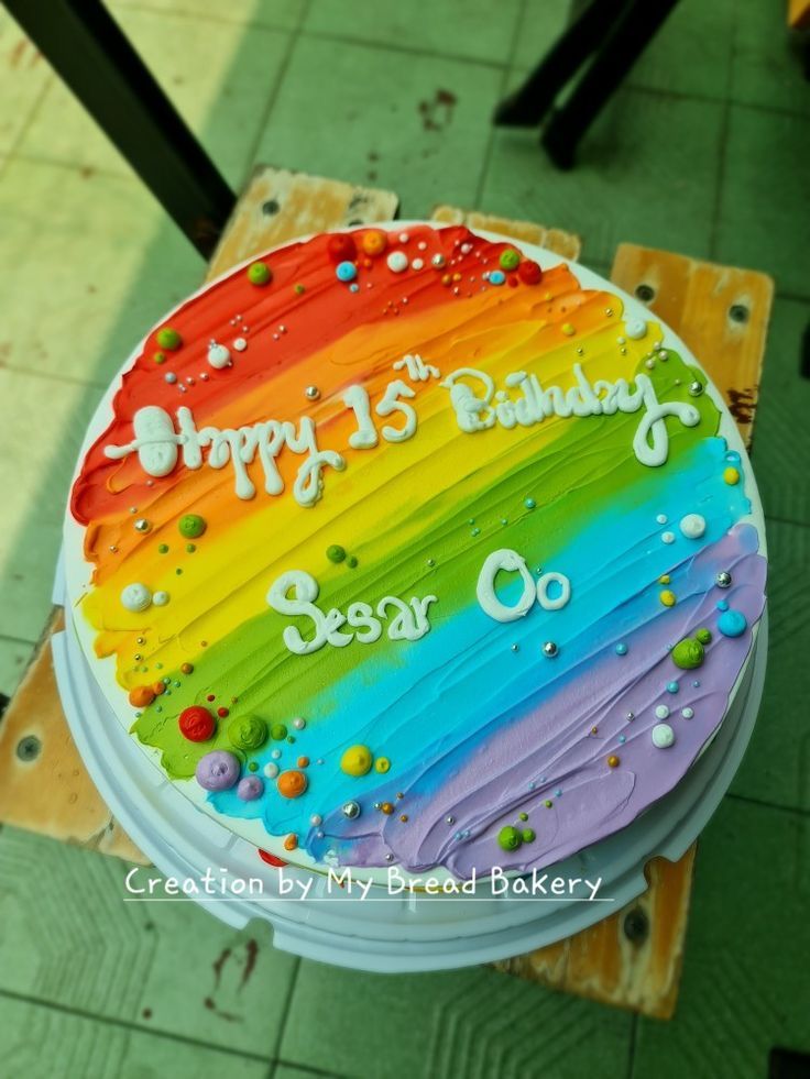 a birthday cake with rainbow frosting and happy 13th birthday written on the bottom layer