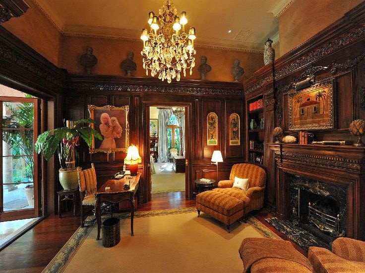 an ornate living room with wood paneling and chandelier