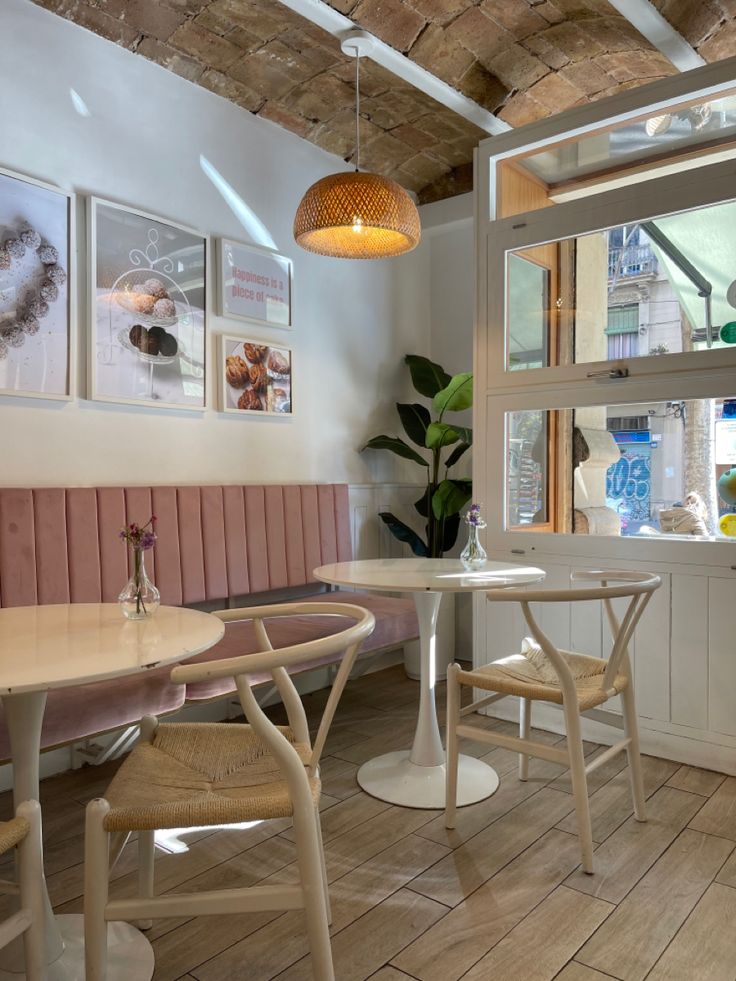 the interior of a restaurant with wooden tables and chairs, white walls and wood flooring