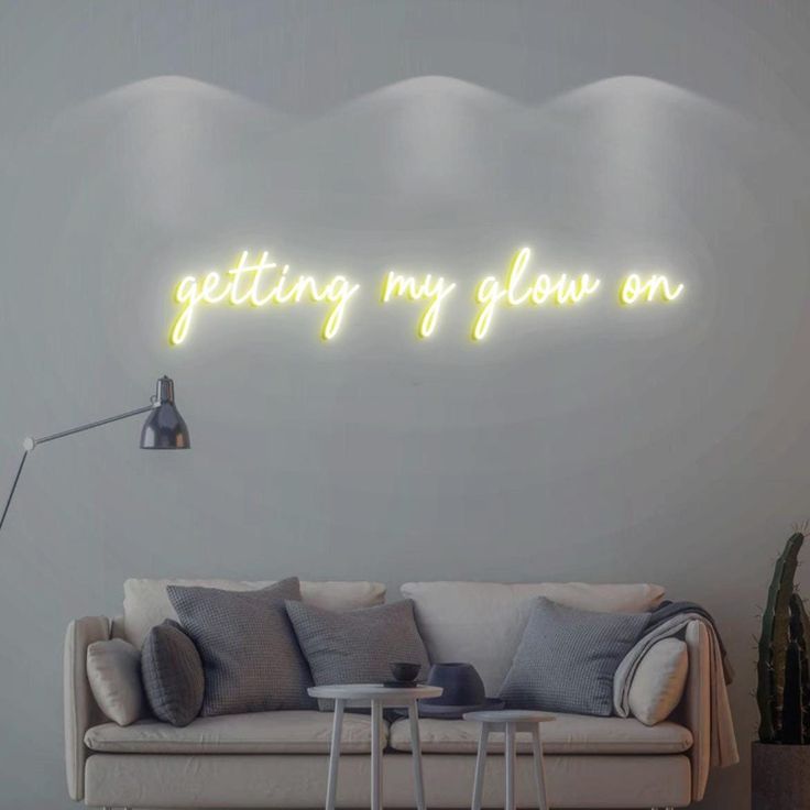 a living room filled with furniture and a neon sign on the wall that says, getting my glow on