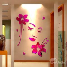 the wall is decorated with pink flowers and butterfly shapes on it's face, along with an orange vase