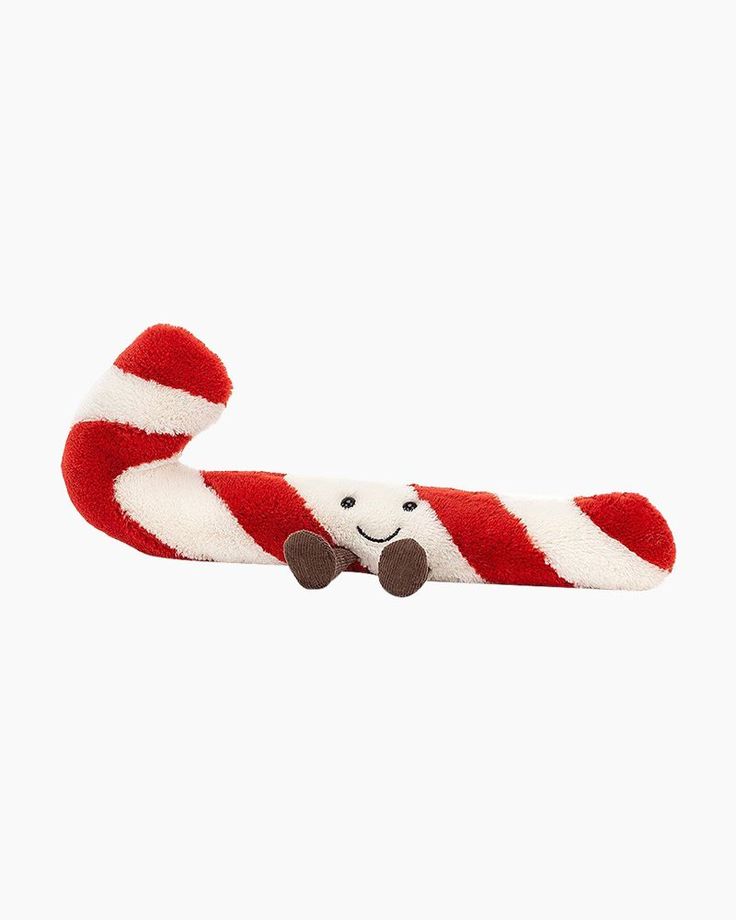 a red and white candy cane with a smiling face on it's end, against a white background