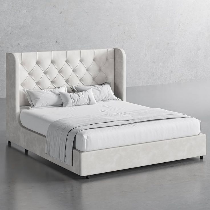 a white bed sitting on top of a gray floor