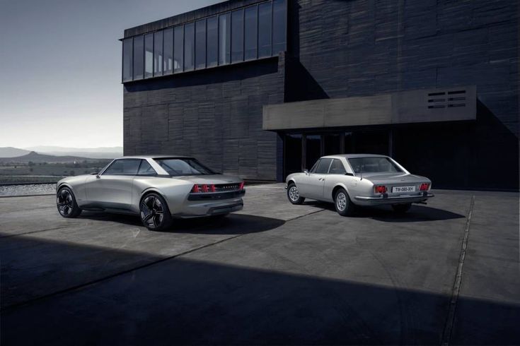 two cars parked next to each other in front of a building with a large window