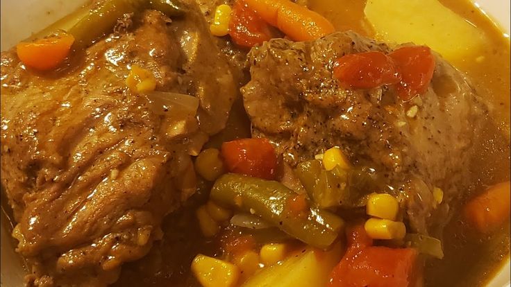 a bowl filled with meat and vegetables on top of a table