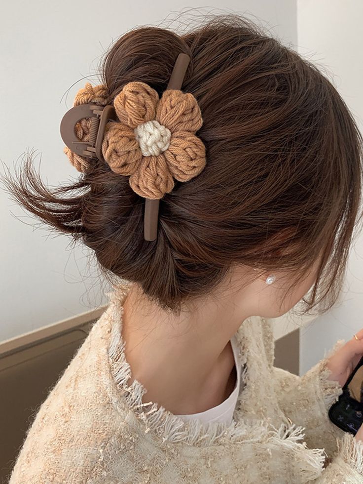 a woman with brown hair and a flower in her hair