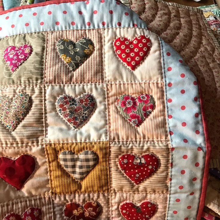 a patchwork heart pillow is laying on the floor